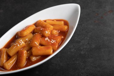 Kızarmış Kore pirinç keki tteokbokki Spicy tteokbokki Kore usulü beyaz bir fincanda.