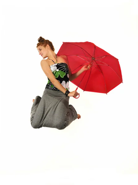 Joyful girl jumping with red umbrella — Stock Photo, Image