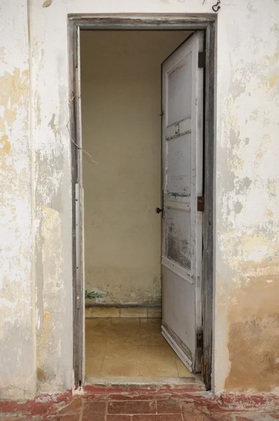 Velha porta aberta em fachada parede gasto — Fotografia de Stock