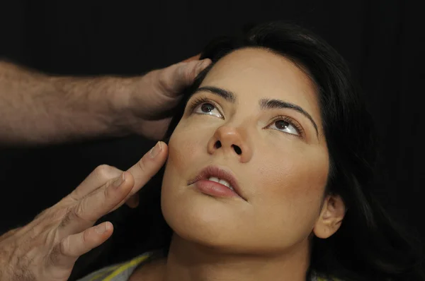 Manos aplicando maquillaje a la chica hispana — Foto de Stock