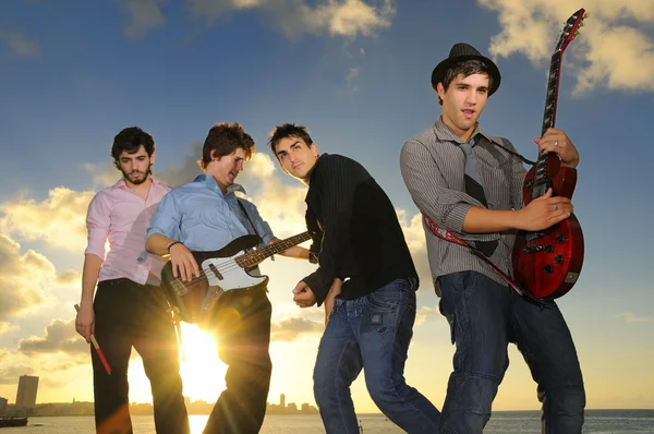 Jovens músicos do sexo masculino com instrumentos ao pôr do sol — Fotografia de Stock