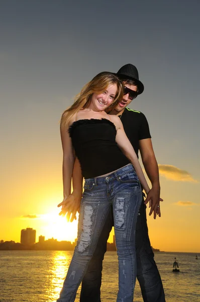 Veselý mladý pár Latinské při západu slunce — Stock fotografie