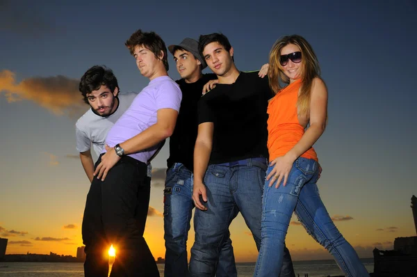 Treandy team av unga människors poserar vid solnedgången — Stockfoto
