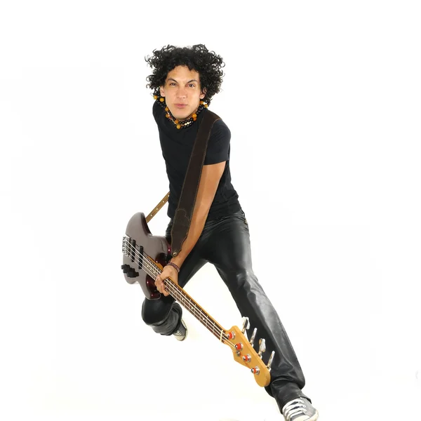 Young guy jumping with electric bass guitar — Stock Photo, Image