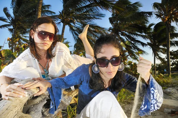 Freundinnen in Sommerkleidung amüsieren sich am tropischen Strand — Stockfoto