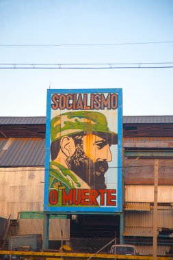 Old factory in Havana with the image of Fidel Castro clipart