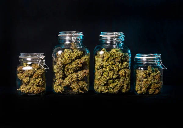 Getrocknete Cannabisknospen Die Einem Glas Über Schwarzem Hintergrund Isoliert Aufbewahrt lizenzfreie Stockfotos