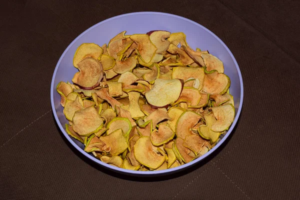 Rodajas de manzana secas y ligeras están en un plato de plástico — Foto de Stock