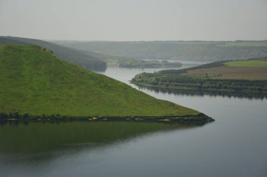 Deniz fiyortları yeşil otlarla kaplı tepelerin arasında dolanıyor.