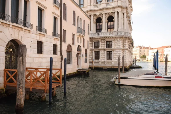 イタリアのヴェネツィアの広い運河古代の建物の間に 太陽に照らされ ボートが乗っています — ストック写真