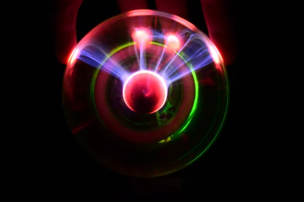 Pelota de plasma con diferentes colores iridiscentes sobre fondo negro — Foto de Stock