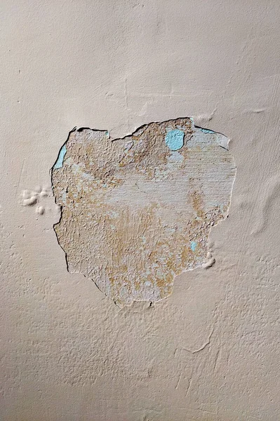 На бежевій стіні пляма тріщинної штукатурки в центрі рами — стокове фото