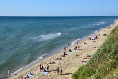 13 Ağustos 2021, Kaliforniya, ABD: Deniz sahilinin uzun ve kumlu sahillerinde güneşlenen birçok insan var