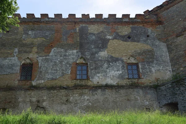Стена средневековой каменной крепости со стенами и решетчатыми окнами — стоковое фото