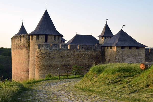 Paved stone road to a medieval stone fortress with several towers