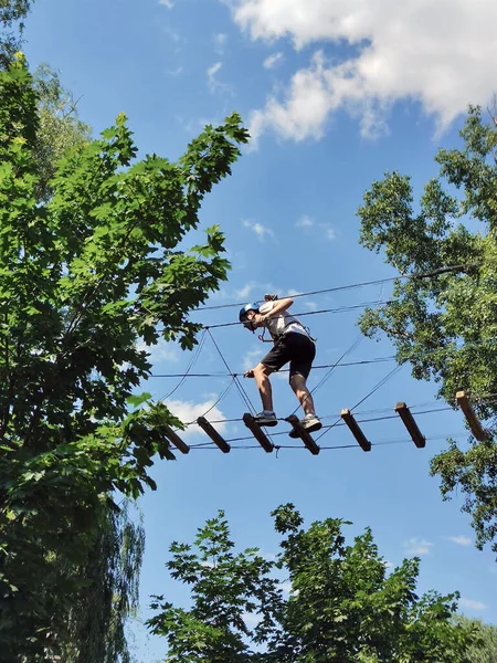 Adolescente Cammina Lungo Ponte Corda Tra Gli Alberi Parco Divertimenti — Foto Stock