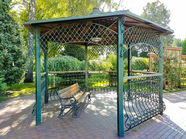 在城市公园有一个屋顶的装饰凉亭 里面有一张空的长椅供人休息 — 图库照片