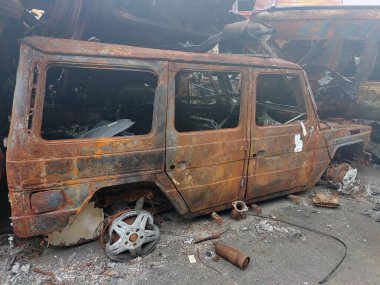 Tamamen yanmış, paslı kenarlı ve içi yanmış bir cip.