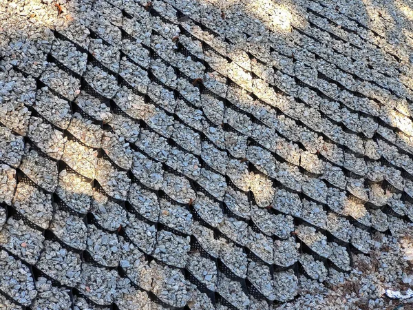 Volumetric geogrid at the base of a new pedestrian road, road construction, reinforcement covered with fine gravel. Modern technologies of road construction, strengthening of hills