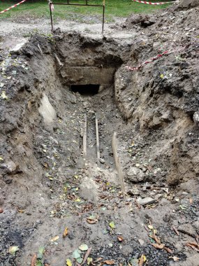 A large long pit with old pipes in perspective at the bottom during the elimination of the accident and their replacement