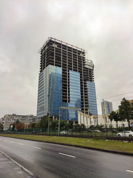 Egy Hatalmas Befejezetlen Felhőkarcoló Üvegfalakkal Egy Aszfaltozott Hátterében Kilátás Alulról — Stock Fotó