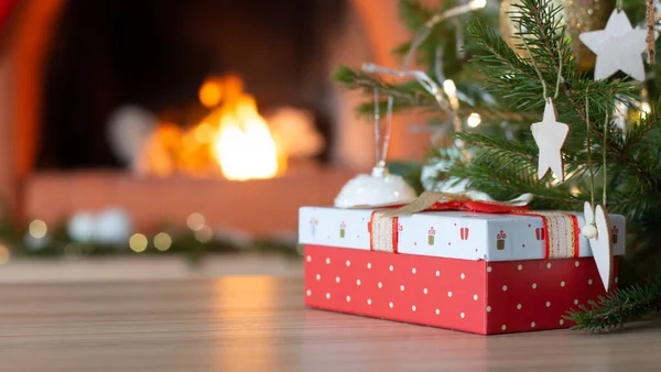 Fondo de vacaciones de Navidad de mesa de madera contra el árbol de Navidad decorado y chimenea Fotos de stock