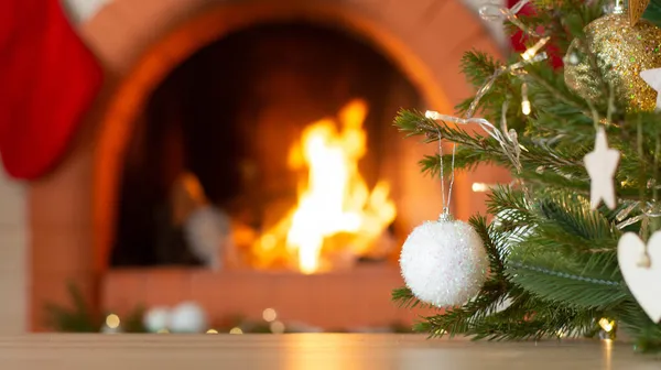 Fondo de vacaciones de Navidad de mesa de madera contra el árbol de Navidad decorado y chimenea Imagen de stock