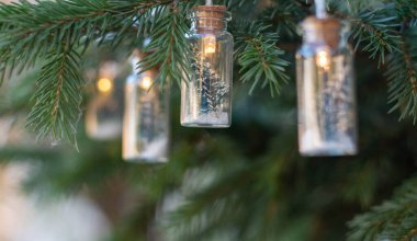 Noel çelengi bir köknar ağacının dallarında, ışıkların yanında. Bayram geleneği. Seçici odak.