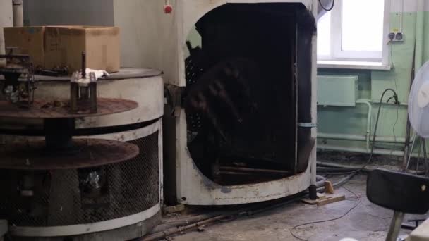 An old furnace for the production of rubber products in a toy factory. The mans hands pull out parts of toys from the press. — Video