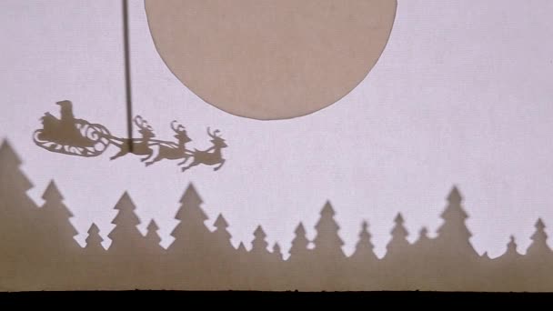 Teatro delle marionette. Babbo Natale su una slitta con renne vola sopra la foresta sotto la grande luna — Video Stock