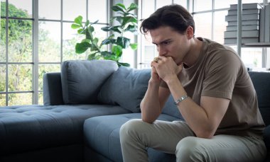 Yakışıklı genç adam endişeli, endişeli ve sıkılmış bir ifade. Genç bir adam evden işe koşuyor, ama sıkılmış ve endişeli oluyor, muhtemelen depresyondan..