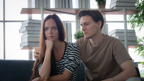 Depression concept, care and treatment. Young woman, Caucasian, white skin, rutted face, worried, having trouble. Couples or lovers are in trouble. Angry with each other. Young man hugging to support.