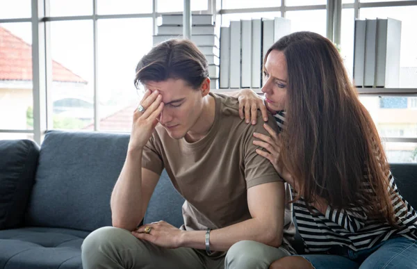 Close up handsome young man An anxious, worried, and bored look on his face. It May be caused by depression get consolation A hug from a girlfriend or lover, close support.