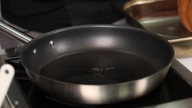 Bir aşçının elini kızartma tavasında pişirirken.