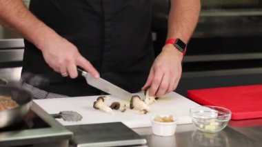 Şef somon ve peynirli suşi ruloları hazırlıyor.