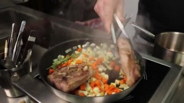 Şef mutfakta yemek pişiriyor.