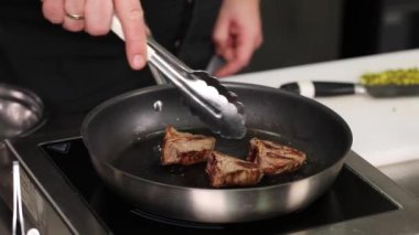 Şef mutfakta et pişiriyor.