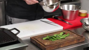 Şef mutfak masasında yemek yapıyor.