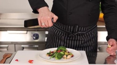 Aşçı mutfakta sebze pişiriyor.