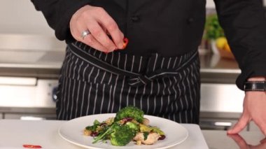 Aşçı mutfakta sebze pişiriyor.