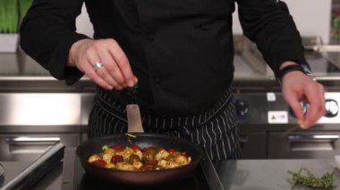 Şef mutfakta yemek pişiriyor.