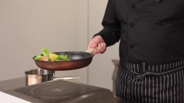 Şef mutfakta yemek hazırlıyor.