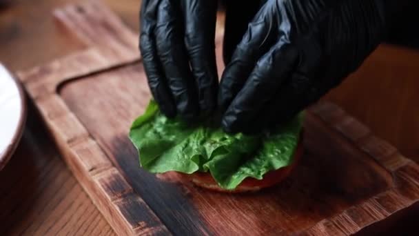Der Koch Kocht Burger Mit Rindfleisch Und Gemüse Auf Holzbrett — Stockvideo