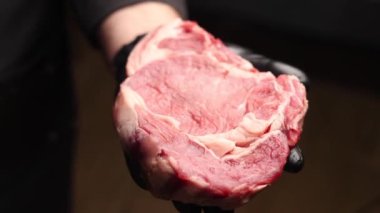 Siyah eldivenli şef biftek hazırlar.