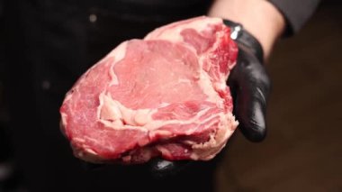 Siyah eldivenli şef biftek hazırlar.