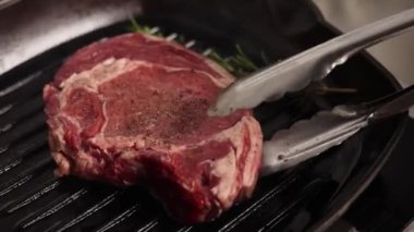 Siyah eldivenli şef biftek hazırlar.