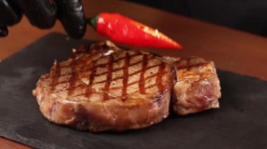 Siyah eldivenli şef biftek hazırlar.