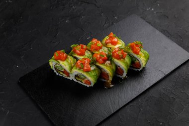 Siyah arka planda sebzeli ve peynirli ızgara somon.