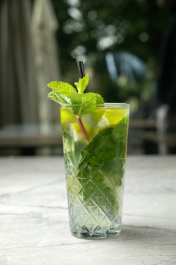 Bir bardak taze limonata, üzerinde nane ve buz olsun.