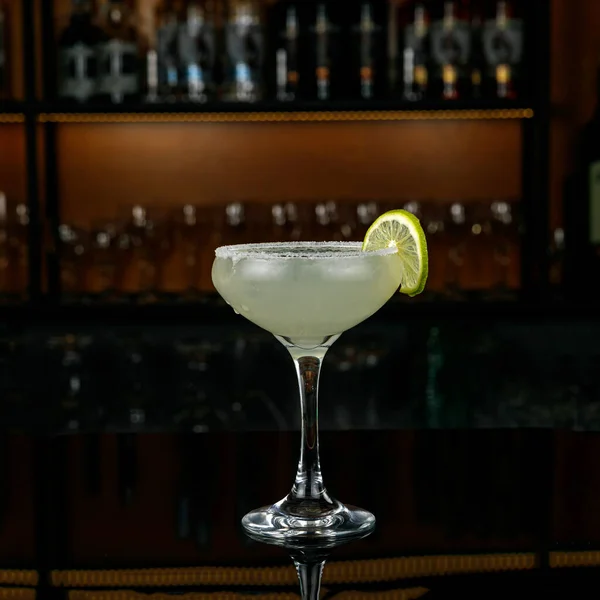 cocktail with a glass of water on a bar counter